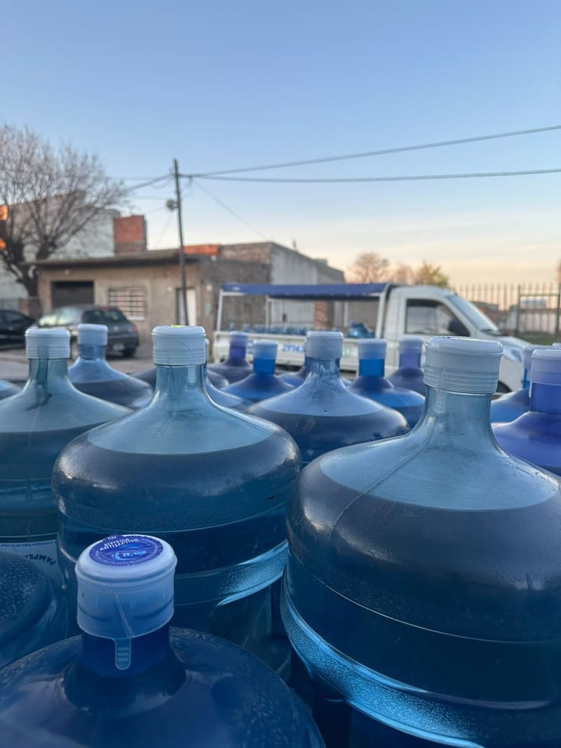 Bidones retornables de 20 litros de Aguas Pampeanas, con la tapa puesta, en la caja de la camioneta