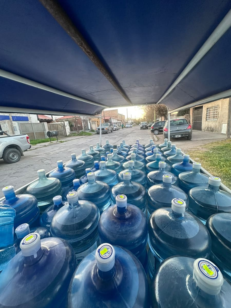 Filas de bidones de 20 litros bajo la lona de una camioneta de Aguas Pampeanas